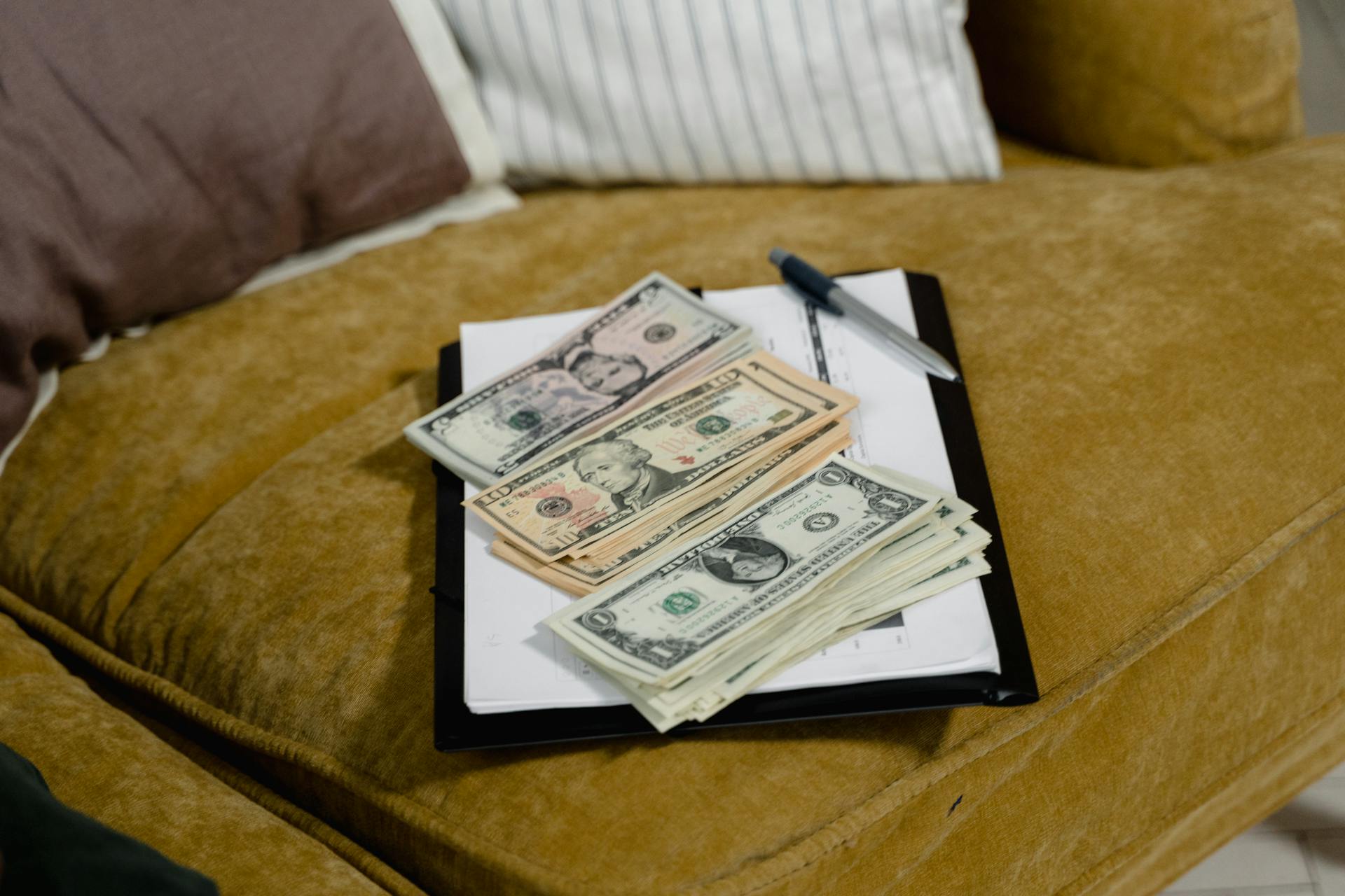 Close-up of US dollar banknotes on a sofa, symbolizing finance and wealth.