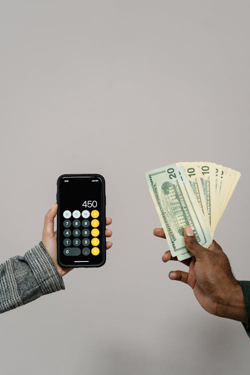 Free Hands Holding a Calculator and Cash Money Stock Photo