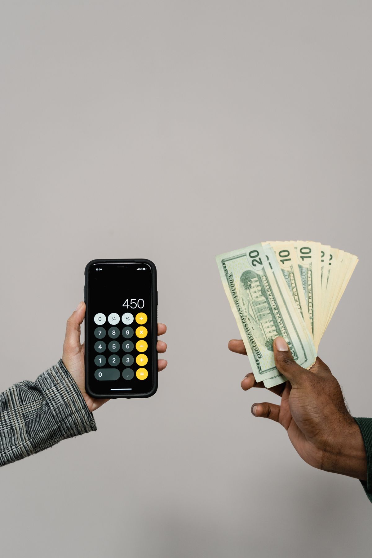 Hands using a calculator while managing cash and financial expenses