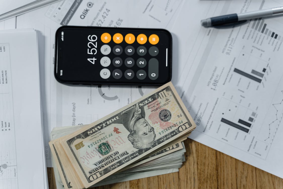 Free Cash Money and a Calculator on White Paper Printout Stock Photo
