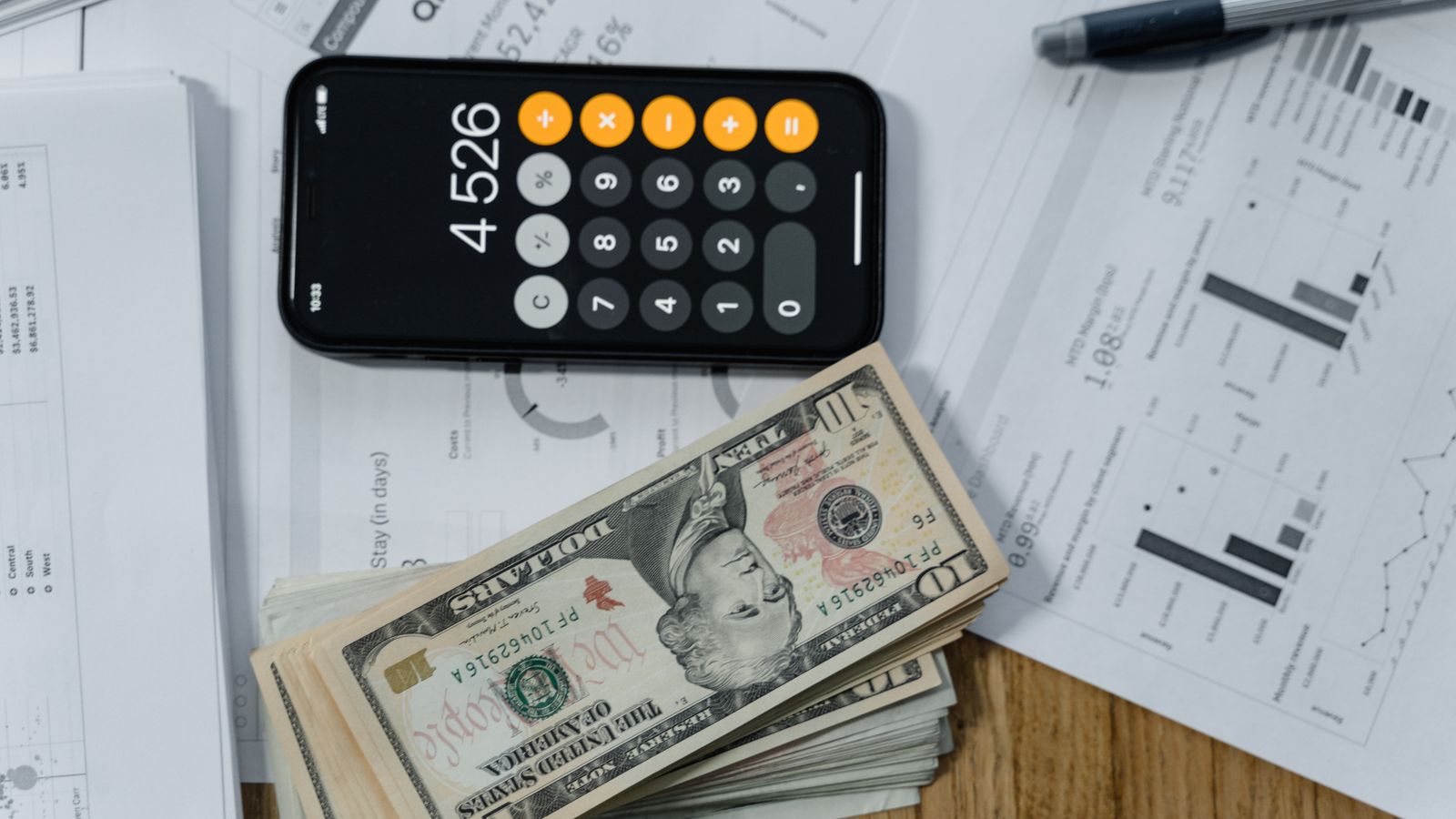 Calculadora, dinero y documentos financieros sobre un escritorio