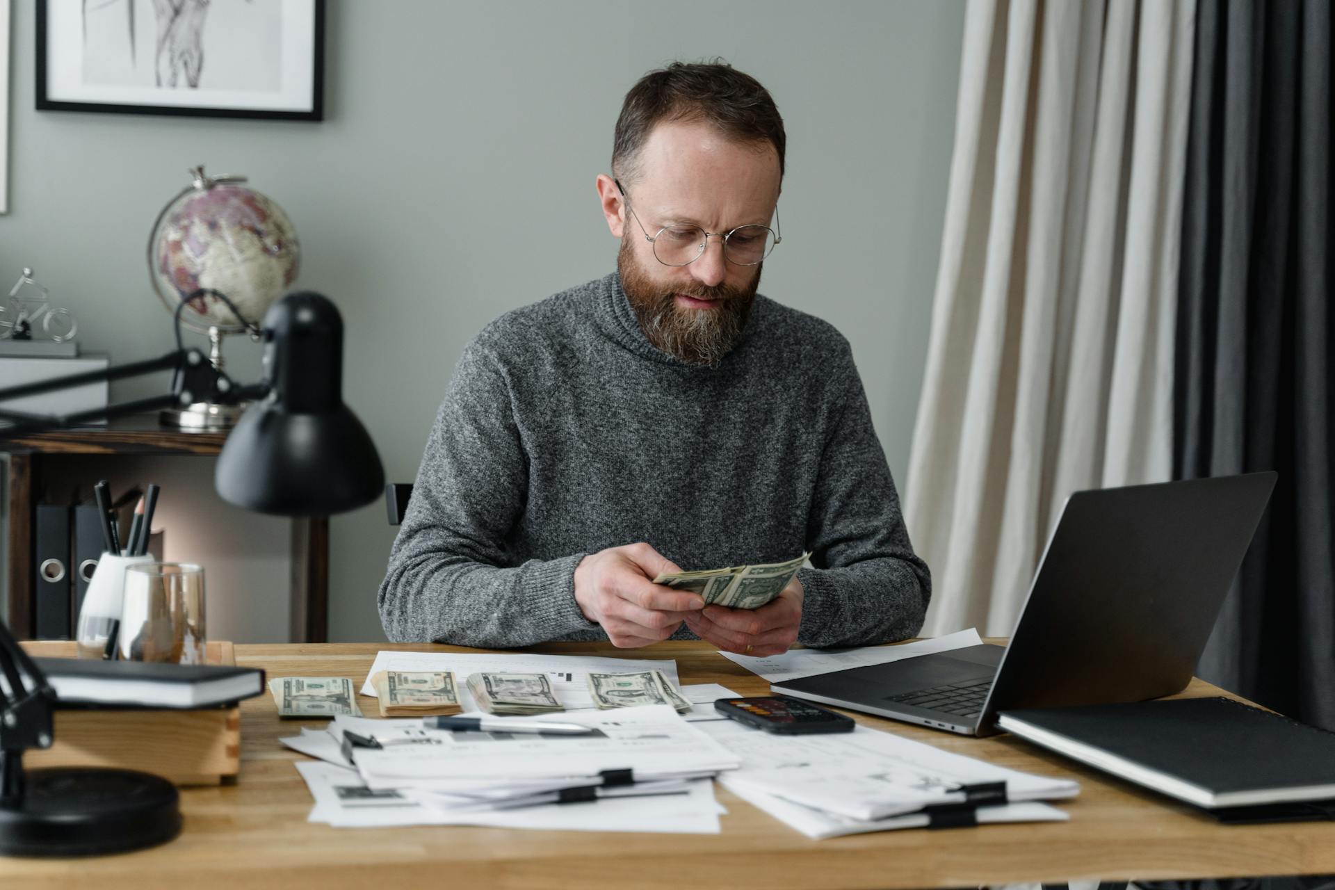 A Man in Gray Long Sleeves Shirt Counting Cash Money