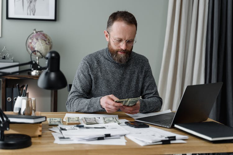 A Man In Gray Long Sleeves Shirt Counting Cash Money