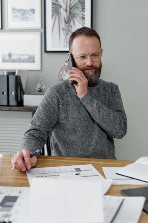 Free A Man in Gray Long Sleeves Using a Mobile Phone Stock Photo