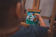 A Child Painting on a Wooden Easel Stand