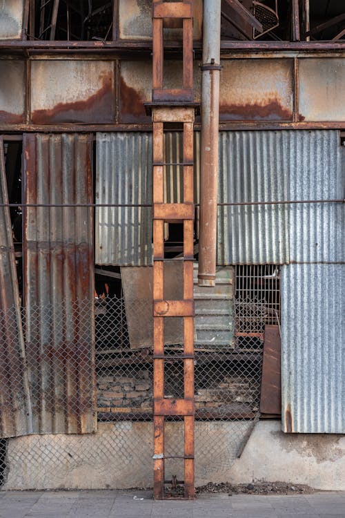 A Steel Pipe and Tower Near a Chain Link Fence 