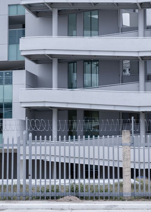 Free Contemporary apartment complex with a minimalist design and fenced enclosure. Stock Photo