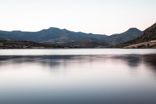 Free Peaceful lake with a stunning view of distant mountains at dusk. Stock Photo
