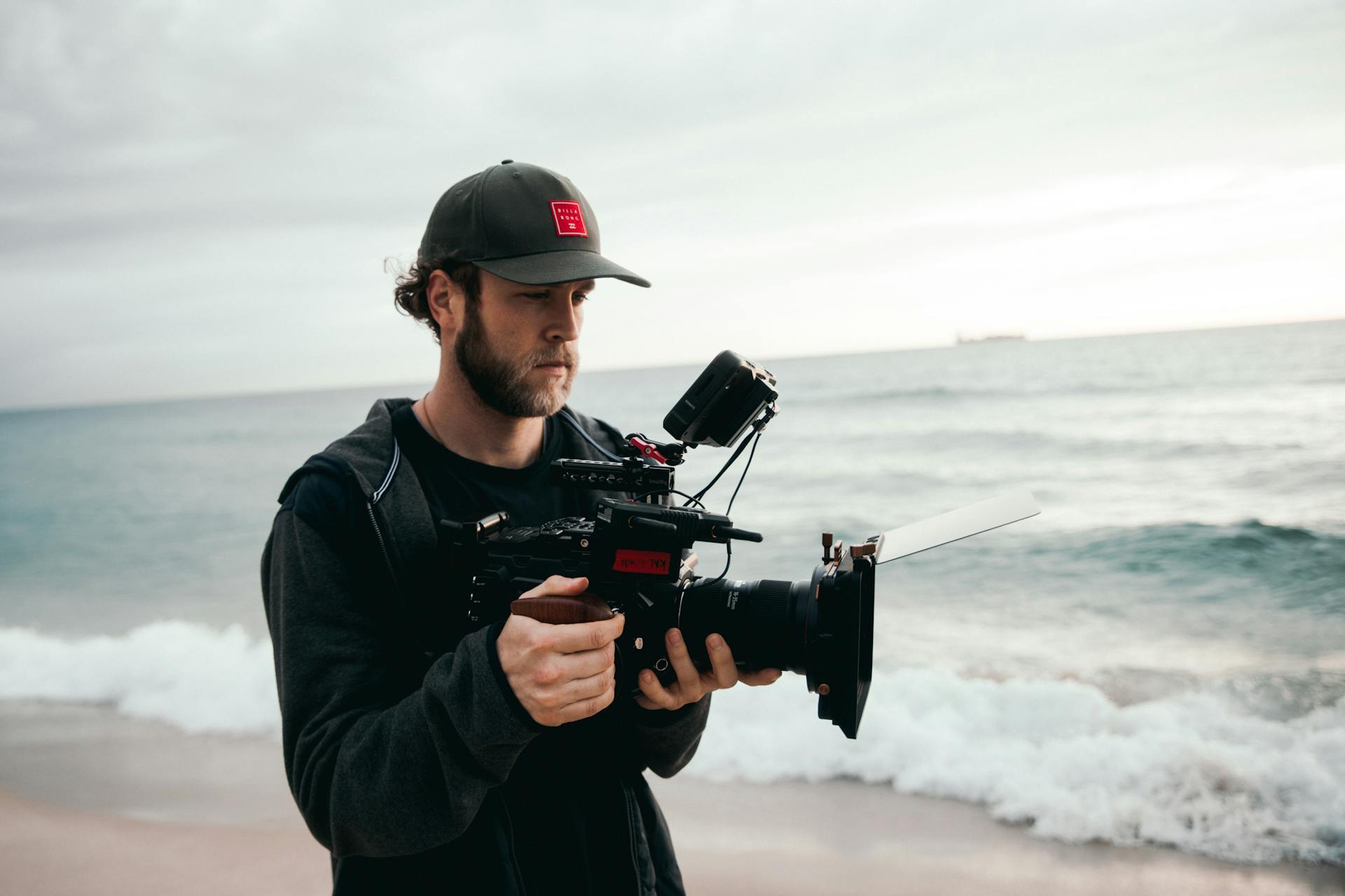 A Cameraman Filming on the Beach