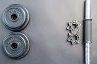 哑铃和两个哑铃重物摆放在中性灰色表面上