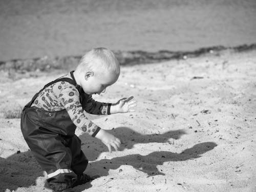 Free Grayscale Photography Of Toddler On Beach Sand Stock Photo