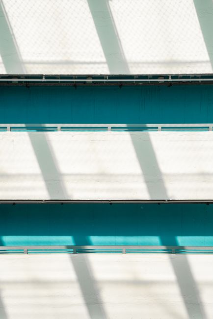 Symmetrical shadows create a geometric design on a modern building facade.
