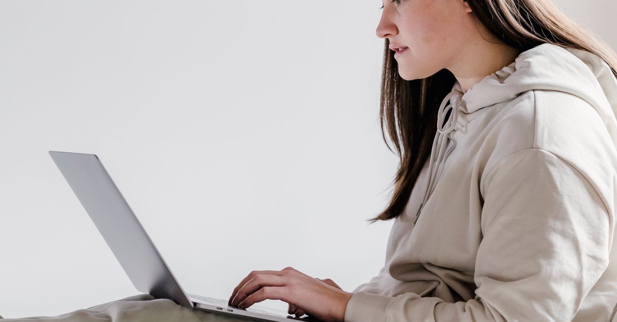 Woman Browsing Computer Serious woman browsing laptop in decorated bedroom · Free Stock Photo