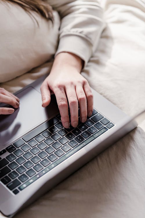 Free Crop woman surfing modern netbook in bedroom Stock Photo