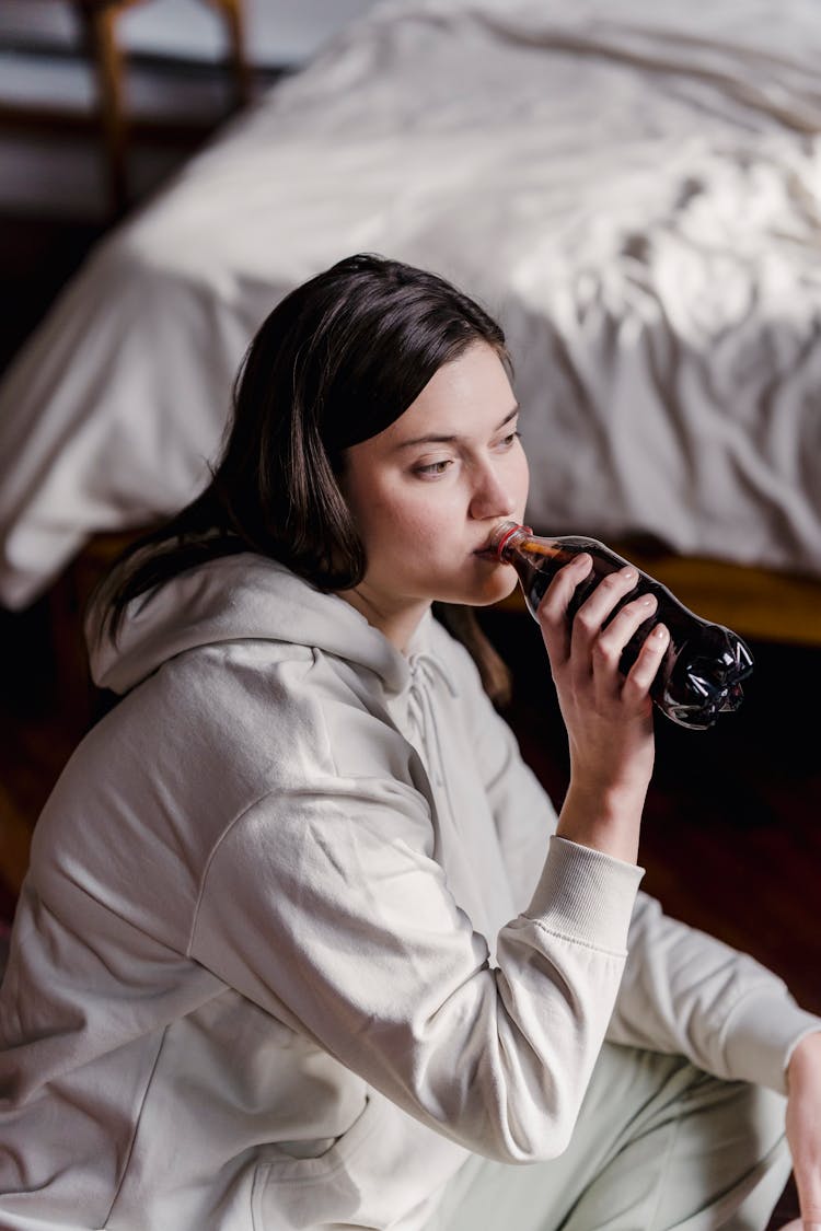 Calm Woman Drinking Soda In Bedroom