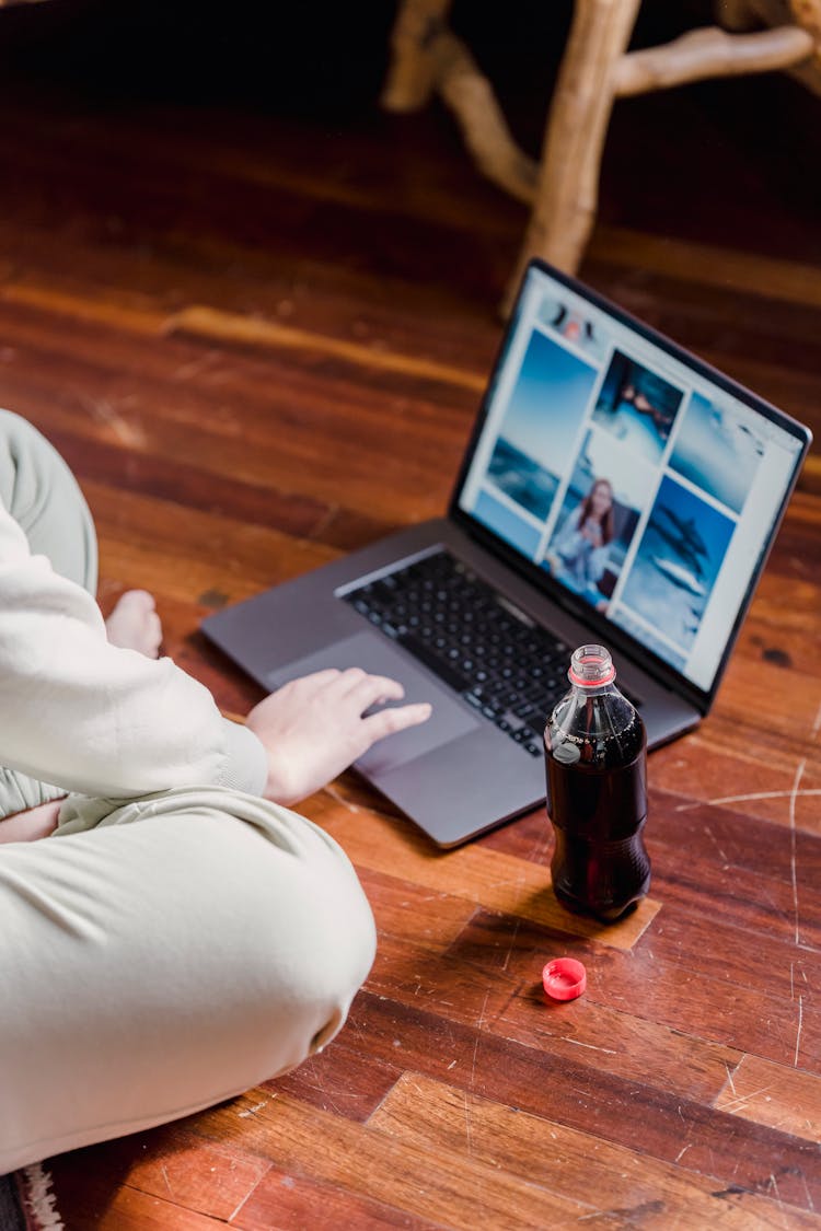 Crop Person Browsing Laptop On Floor