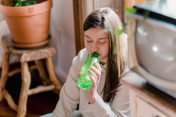 Calm Female Drinking Soda At Home