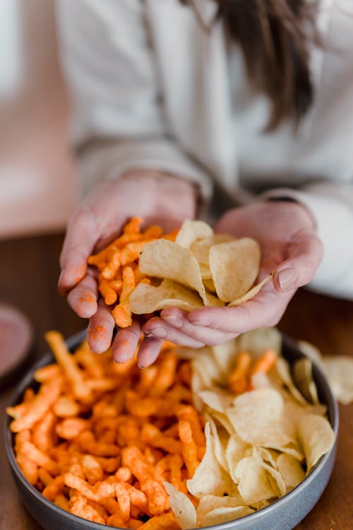 Woman Eating Snacks at Table · Free Stock Photo