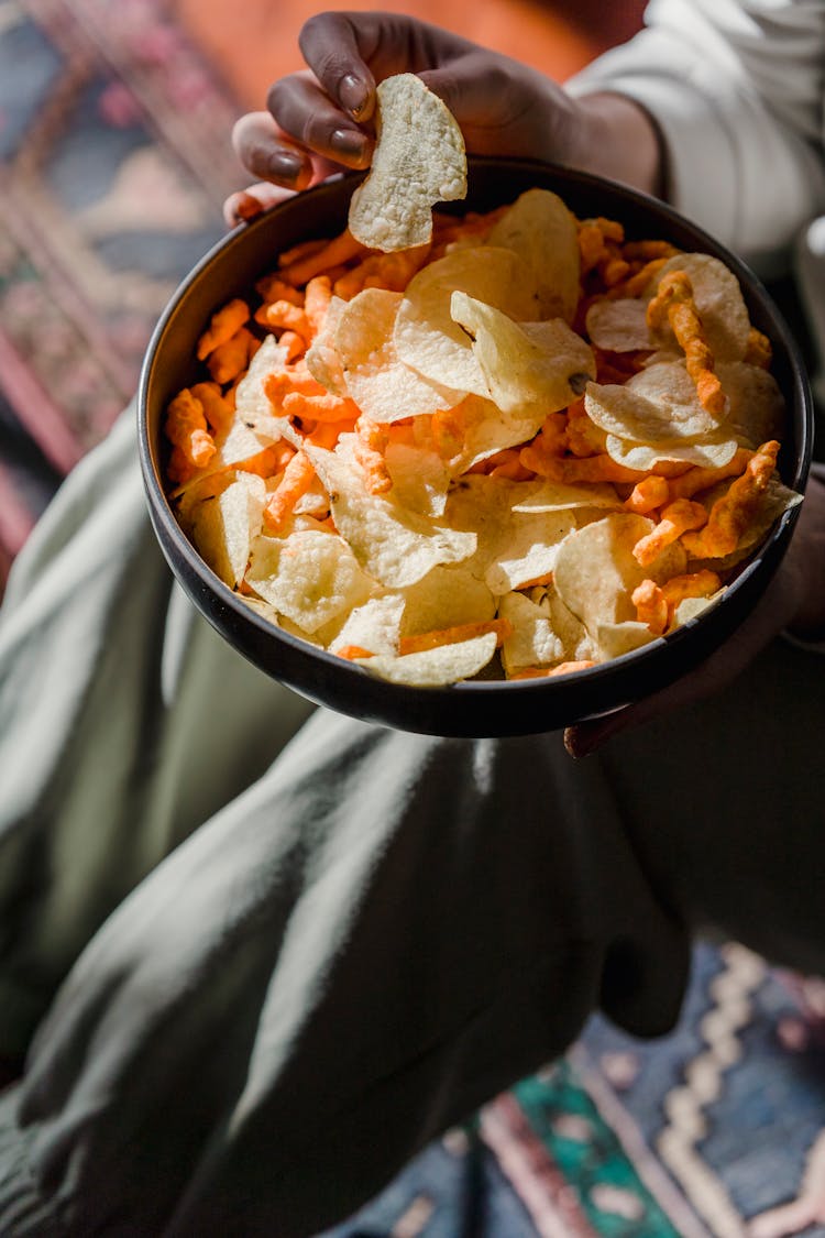 Woman Eating Crusty Crisps In Bowl