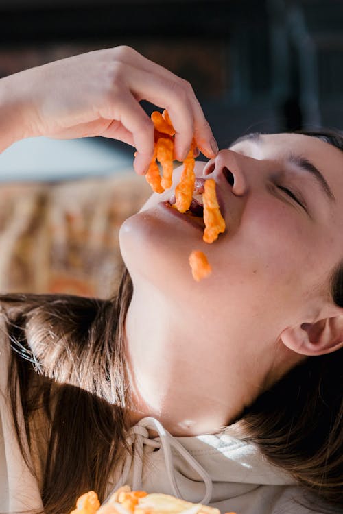 Young woman with eyes closed enjoying tasty snack