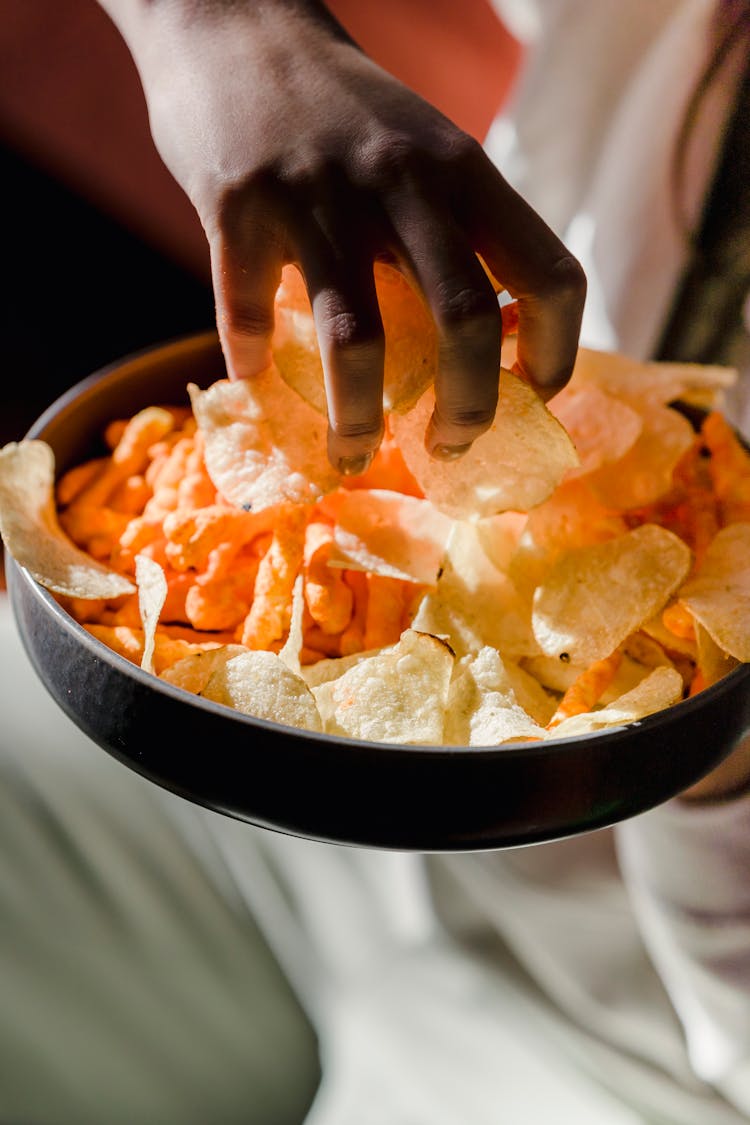 Woman Taking Tasty Crisps From Bowl