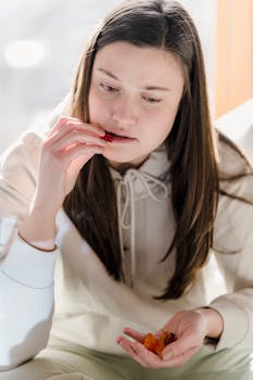 A young woman enjoys a sweet snack indoors, captured in soft daylight.