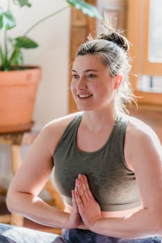 Relaxed young woman in yoga pose, enjoying a home workout in natural light.