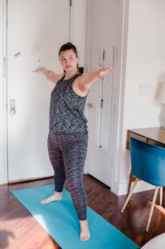 A woman performs a yoga pose in a modern home interior, promoting fitness and relaxation.