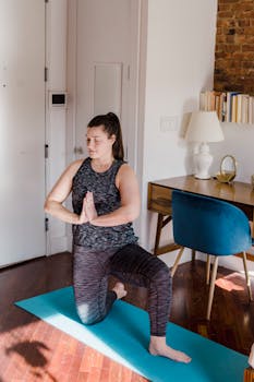A woman practicing yoga in a cozy home setting with natural light.