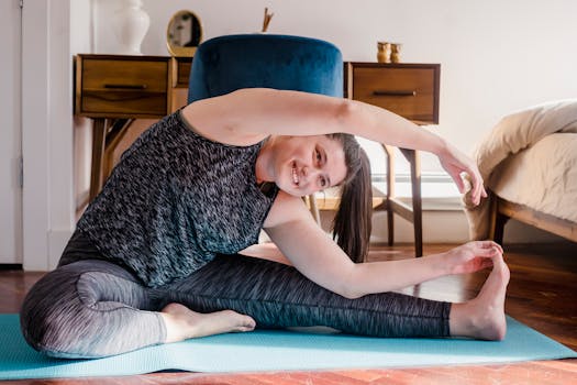 Smiling woman stretching on a yoga mat in a cozy home setting.