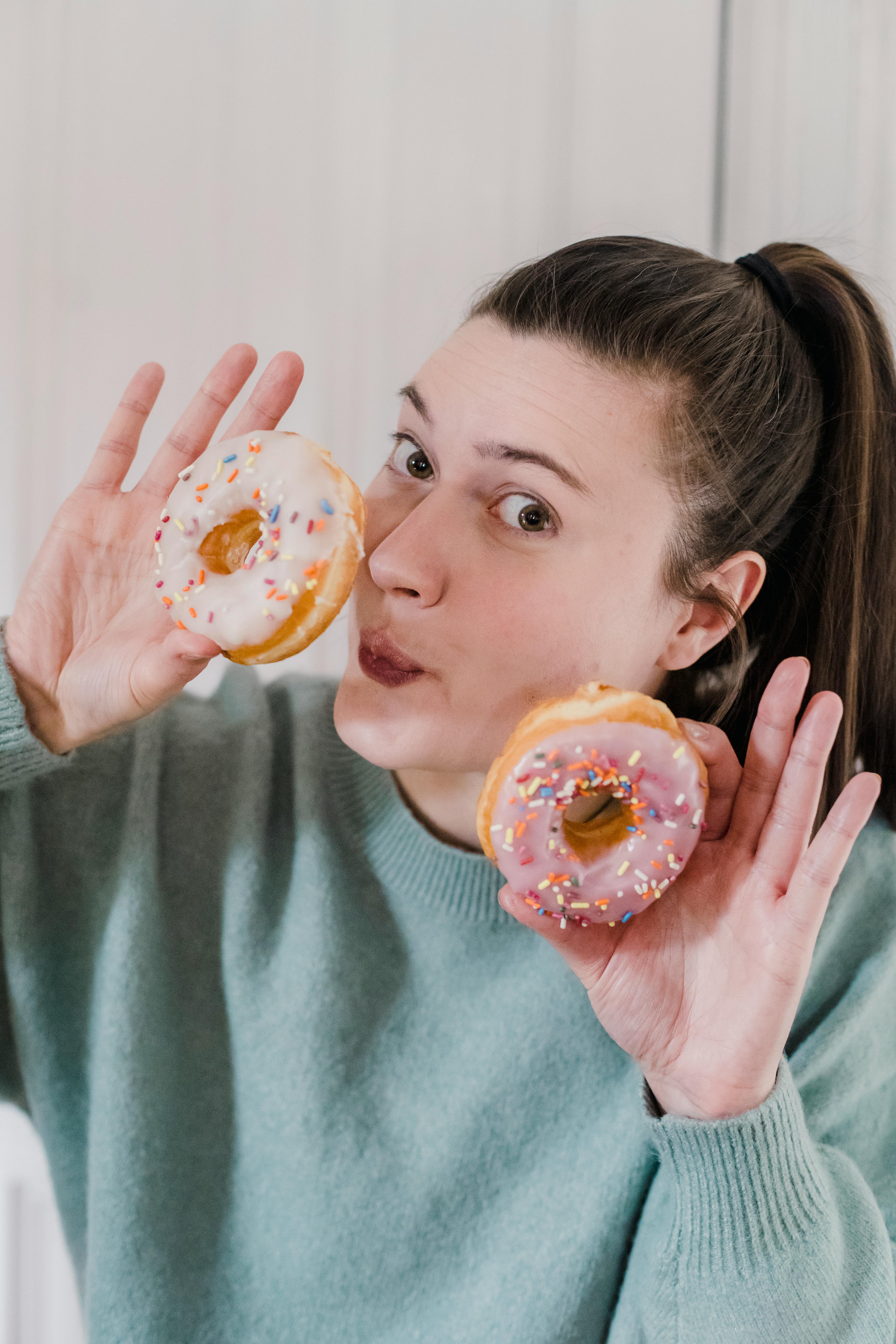 positive woman with sweet donuts