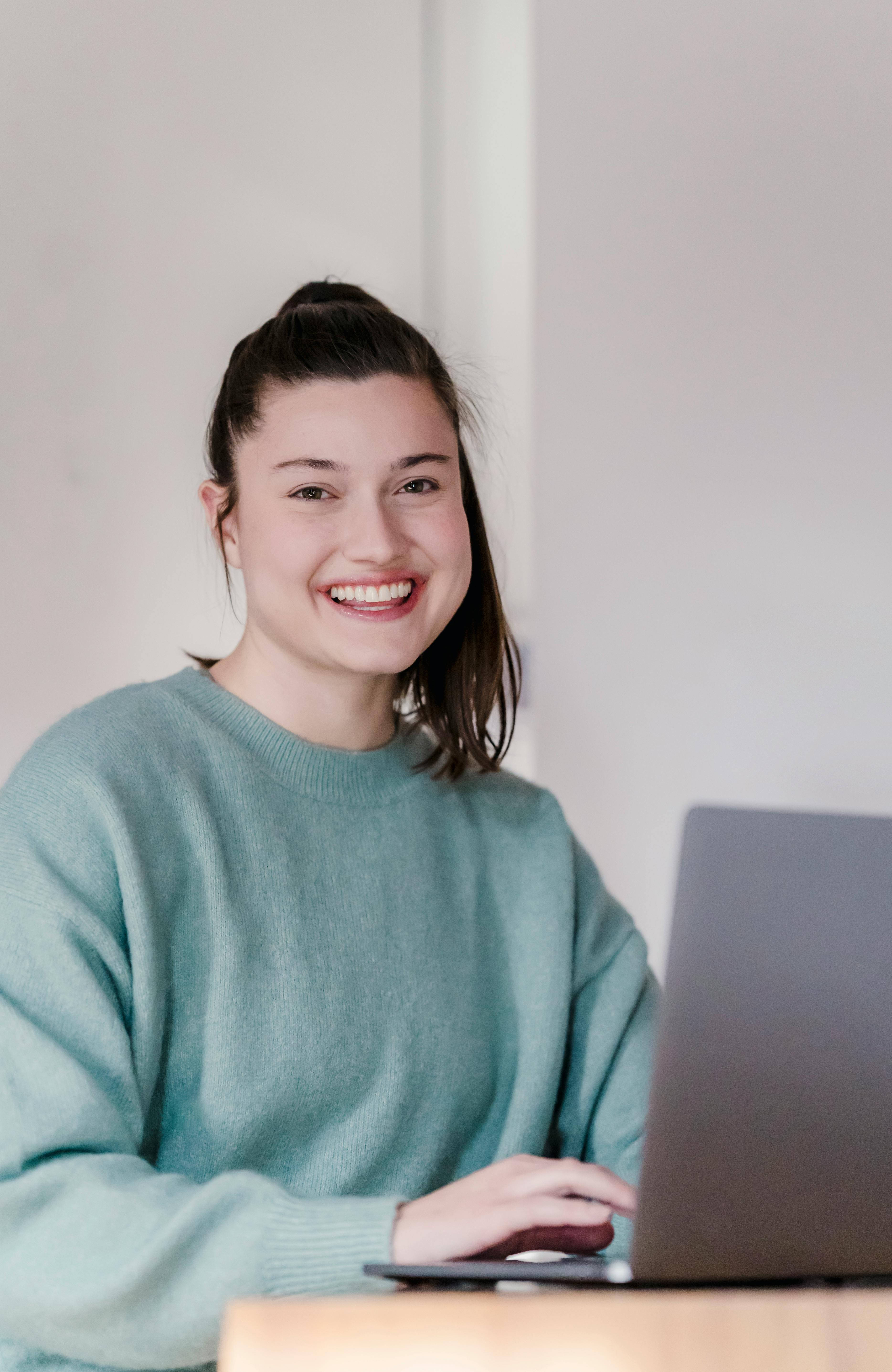 smiling woman working on laptop at home