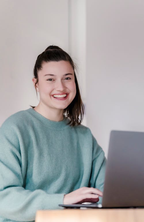 Smiling woman working on laptop at home