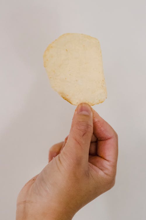 Free Fried crispy potato chip in hand Stock Photo