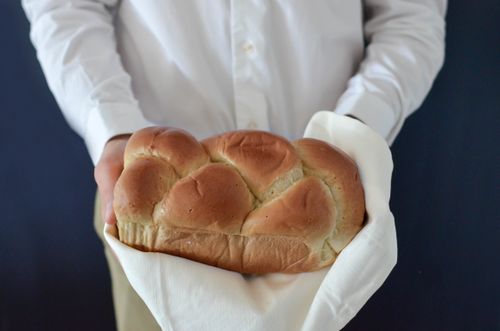 Free Fresh challah loaf held in hands, symbolic of tradition and celebration. Stock Photo