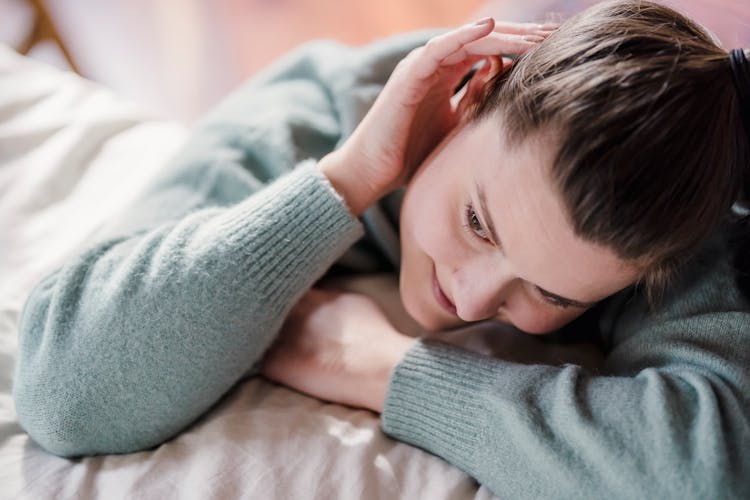 Woman Putting Arms On Bed And Head On Shoulder