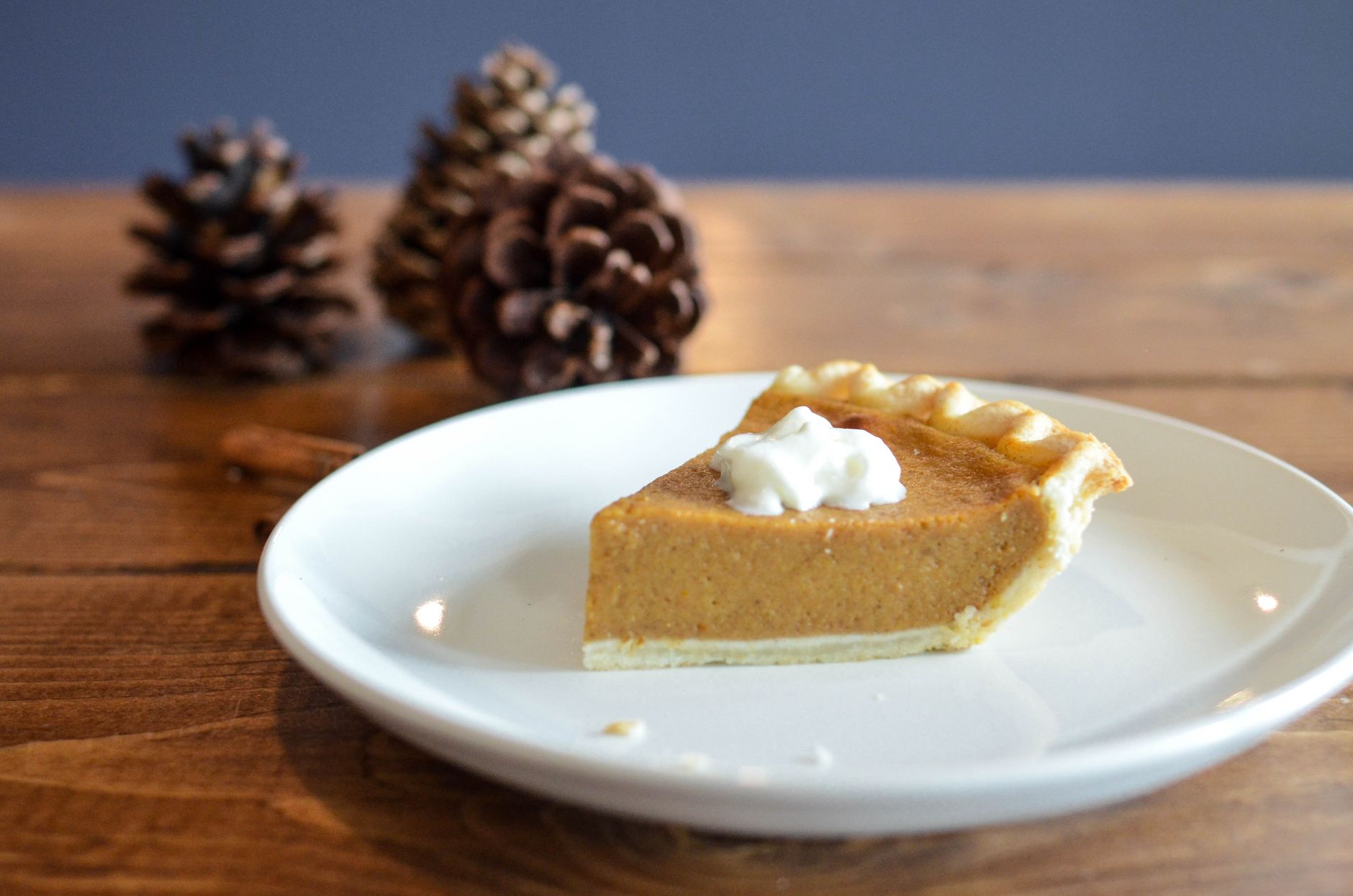 Slice of pumpkin pie with whipped cream and cinnamon