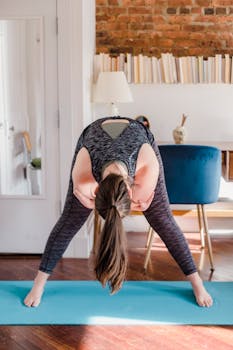 Adult woman doing yoga exercise indoors on mat, promoting relaxation and healthy lifestyle.