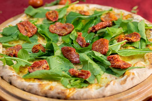 Free Close-up Photo of Basil Pizza in a Round Wooden Tray Stock Photo