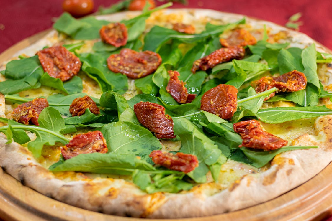 Close-up Photo of Basil Pizza in a Round Wooden Tray