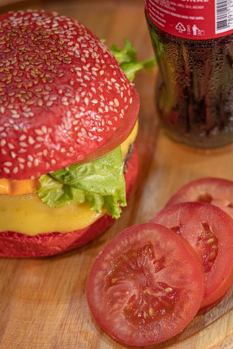 Red Colored Burger Beside Sliced Tomato 