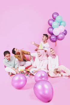 A vibrant party scene with teenagers playing and celebrating against a pink background.