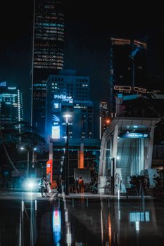 Explore the vibrant night cityscape of Jakarta with illuminated skyscrapers and lively streets.