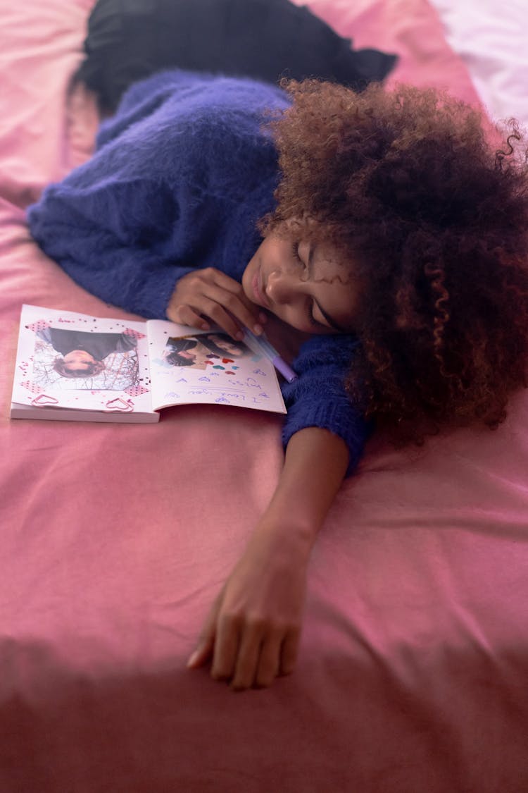 A Woman With Afro Hair Lying On The Bed 