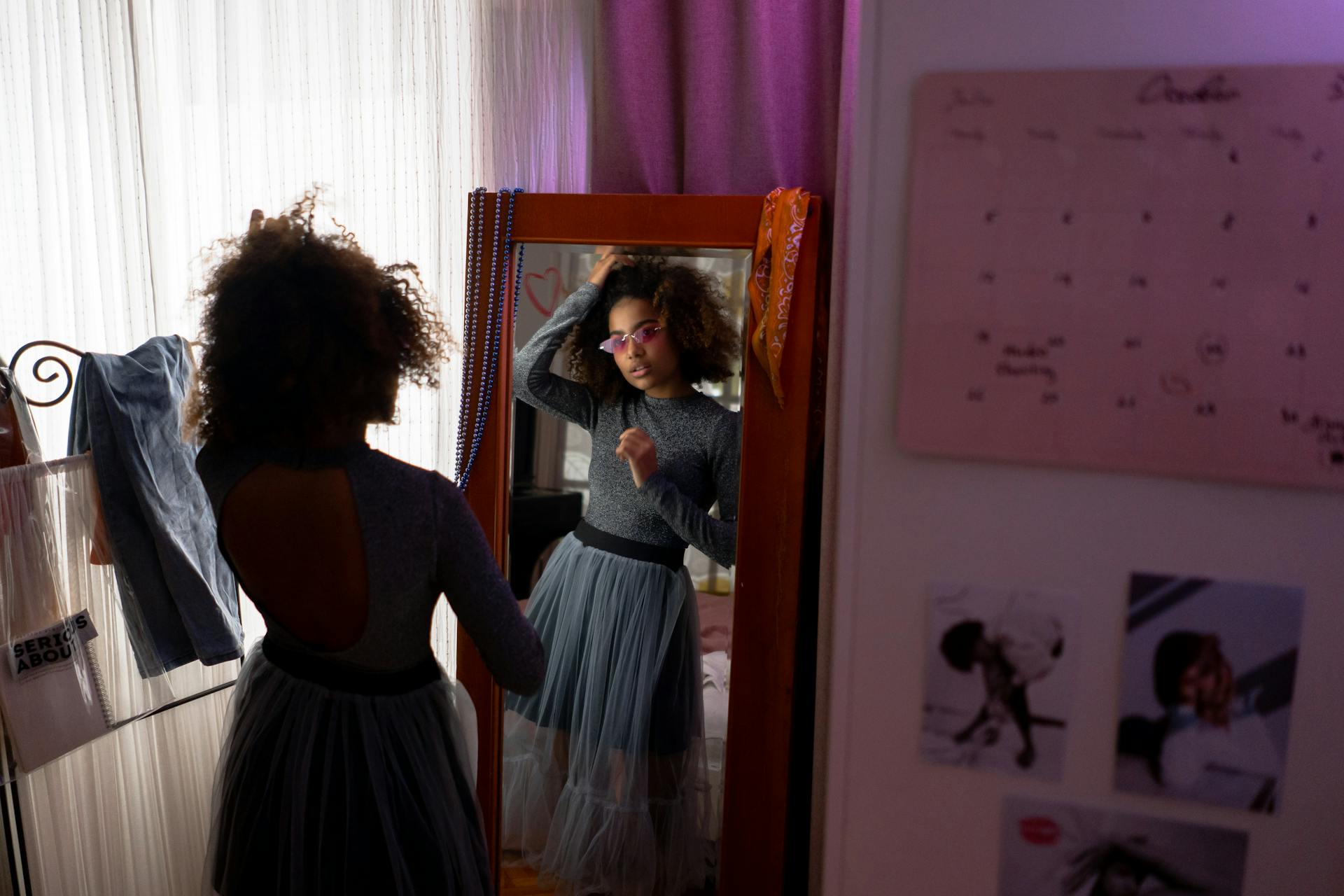 Teenage Girl Standing in Front of a Mirror Wearing Gray Long Sleeve Dress