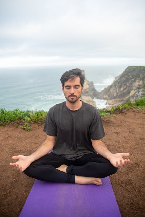 Man Meditating near Cliff