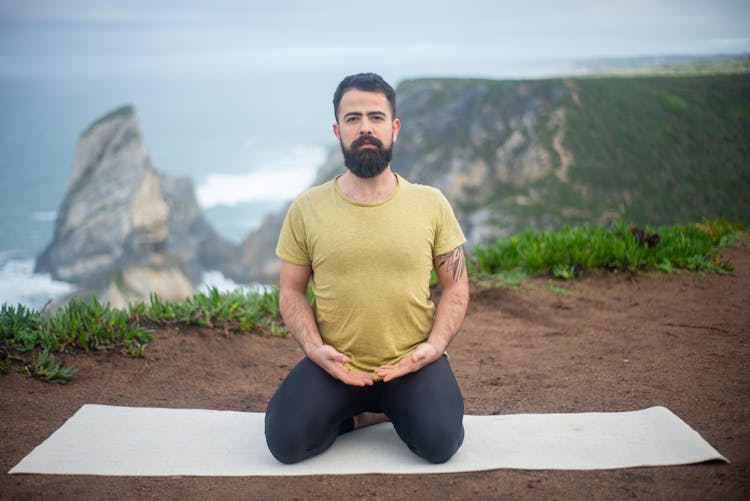 Bearded Man Kneeling On A Yoga Mat