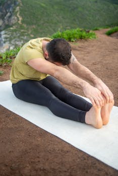 Adult man stretches on yoga mat in nature during daytime in Portugal.