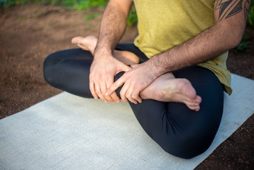 Close-up of a man in a yoga pose on a mat outdoors in Portugal, showcasing relaxation and mindfulness.