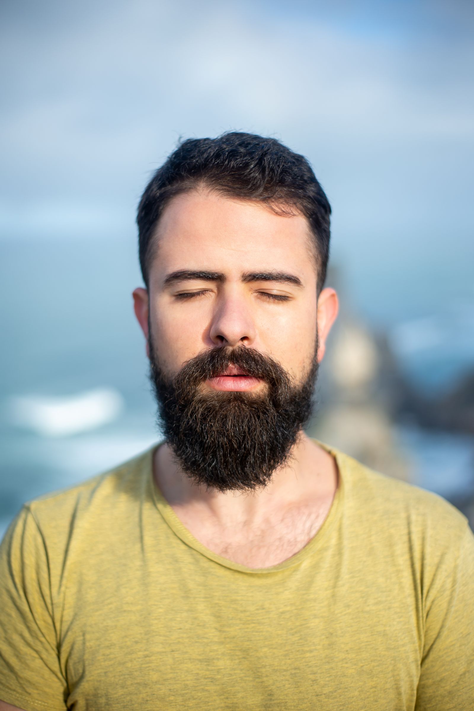 A man with his eyes closed, breathing, calm.